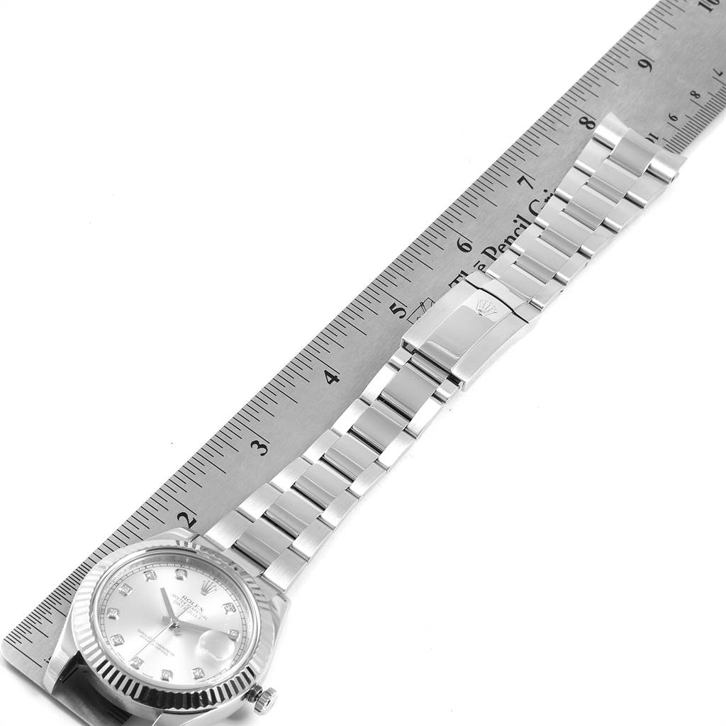 The image shows a top-down view of a Rolex Datejust 41 116334 Men's Stainless Steel Silver Dial 116334 Men's Stainless Steel Silver Dial model watch and its metal bracelet next to a ruler.
