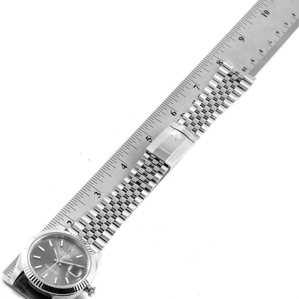 The Rolex Datejust 41 126334 Men's Stainless Steel Grey Dial 126334 Men's Stainless Steel Grey Dial model watch is shown from above, featuring its face, bezel, bracelet, and clasp, alongside a ruler.
