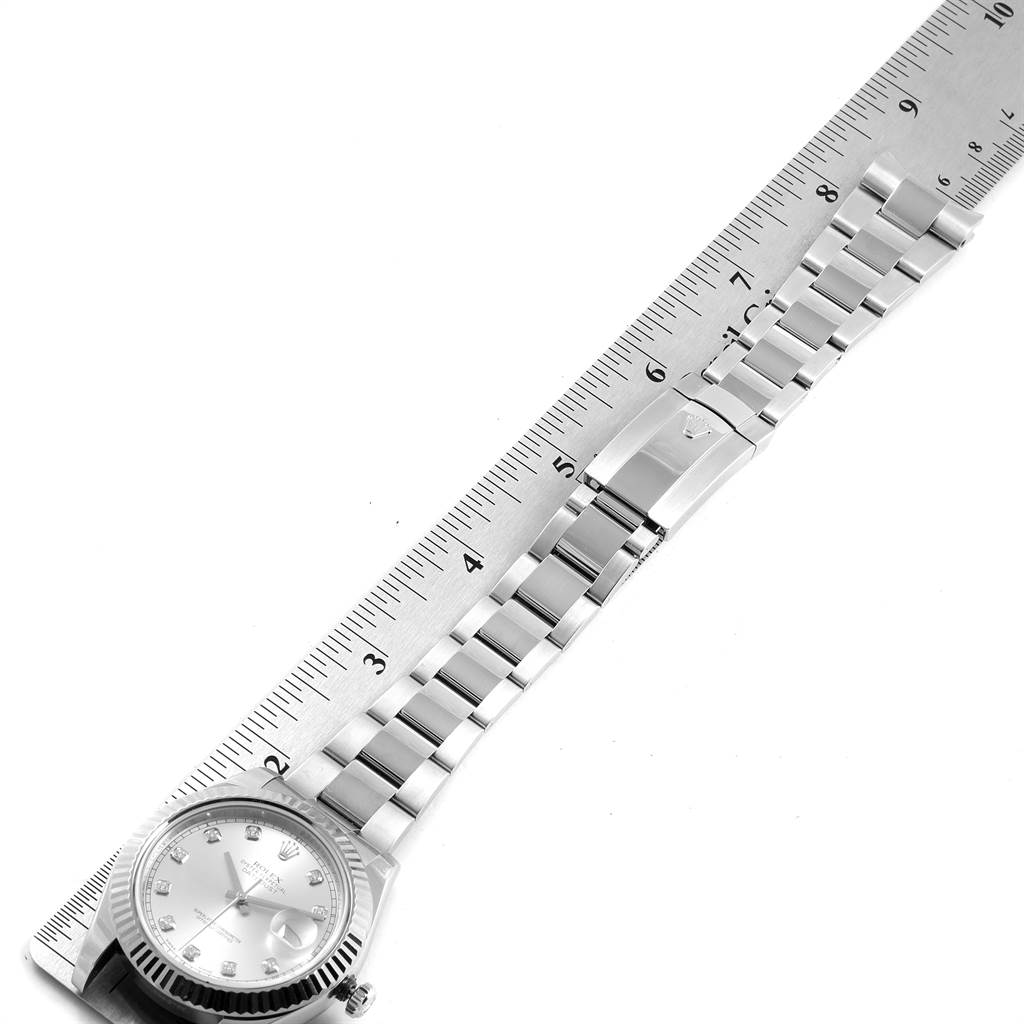 The image shows a top-down view of a Rolex Datejust 41 116334 Men's Stainless Steel Silver Dial 116334 Men's Stainless Steel Silver Dial watch lying next to a ruler, displaying its band and face.