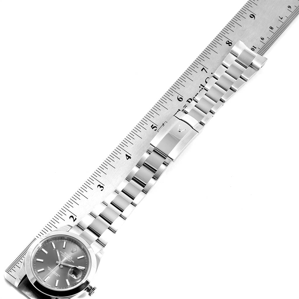 This image shows the Rolex Datejust 41 126300 Men's Stainless Steel Grey Dial 126300 Men's Stainless Steel Grey Dial from a top-down angle, highlighting the watch face, bracelet, and clasp against a ruler.