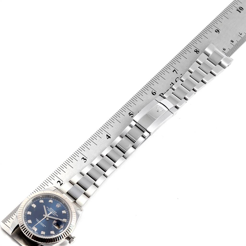 The image shows a Rolex Datejust 41 126334 Men's Stainless Steel Blue Dial 126334 Men's Stainless Steel Blue Dial watch with a blue dial and a stainless steel bracelet, positioned next to a ruler for measurement.