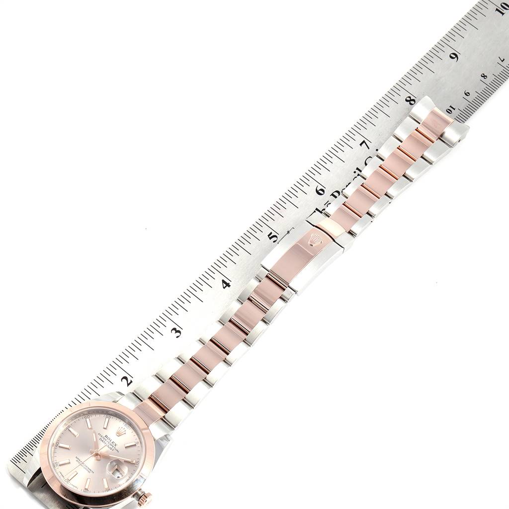 The image shows a top view of a Rolex Datejust 41 126301 Men's Steel and Gold (two tone) Pink Dial 126301 Men's Steel and Gold (two tone) Pink Dial watch with a pink and silver-tone bracelet and a ruler alongside for scale.