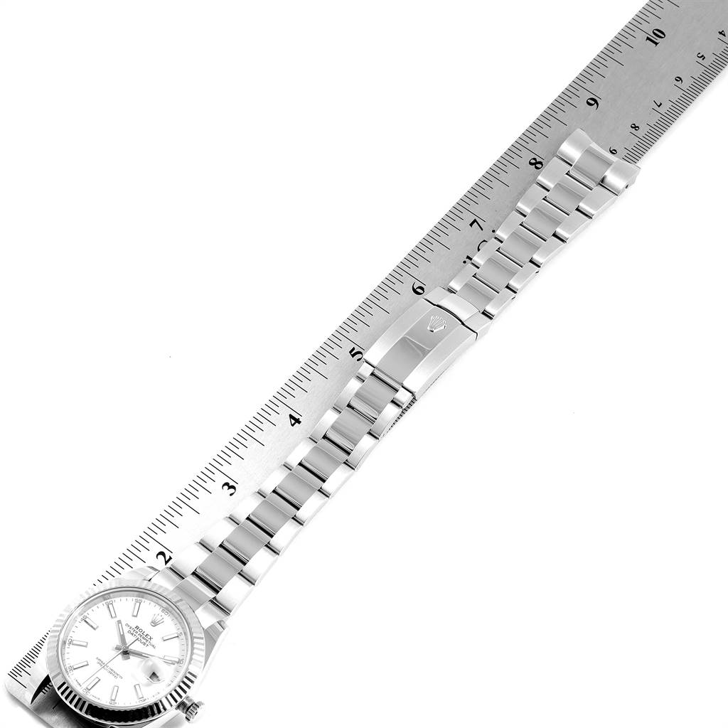 The image shows a Rolex Datejust 41 126300 Men's Stainless Steel White Dial 126300 Men's Stainless Steel White Dial watch placed on a ruler, displaying the watch face and metal bracelet.