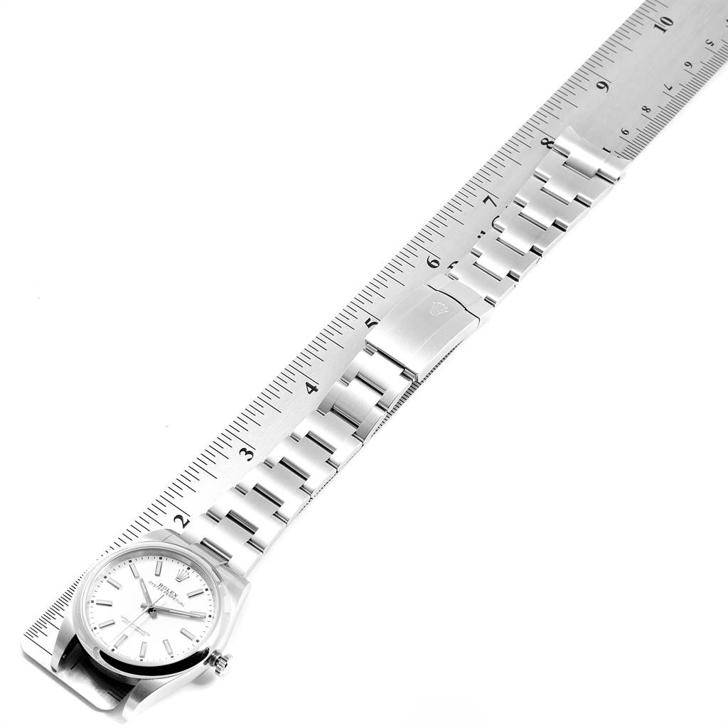 This image shows the entire Rolex Datejust 41 114300 Men's Stainless Steel White Dial 114300 Men's Stainless Steel White Dial watch laid next to a measuring ruler.