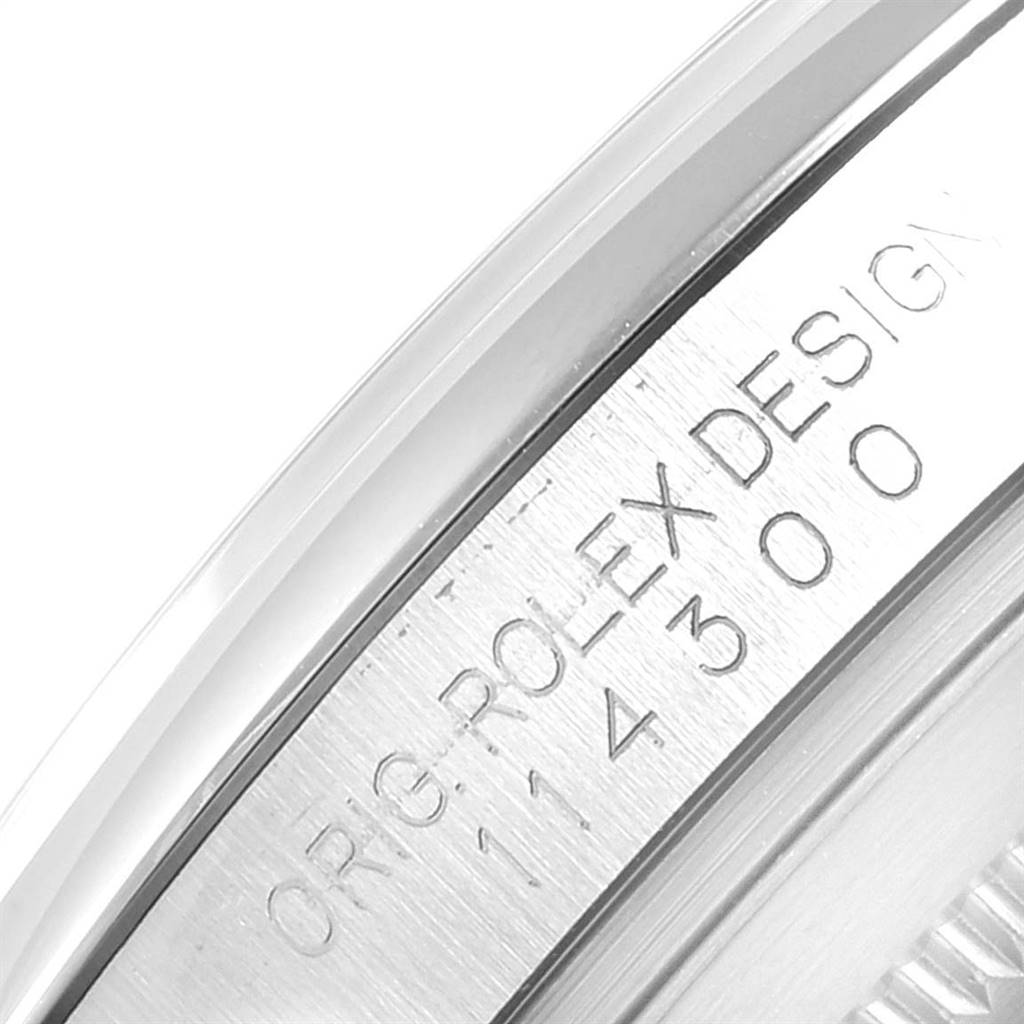 This image shows a close-up of the outer rim of a Rolex Datejust 41 114300 Men's Stainless Steel White Dial 114300 Men's Stainless Steel White Dial watch, highlighting the Rolex engraving.