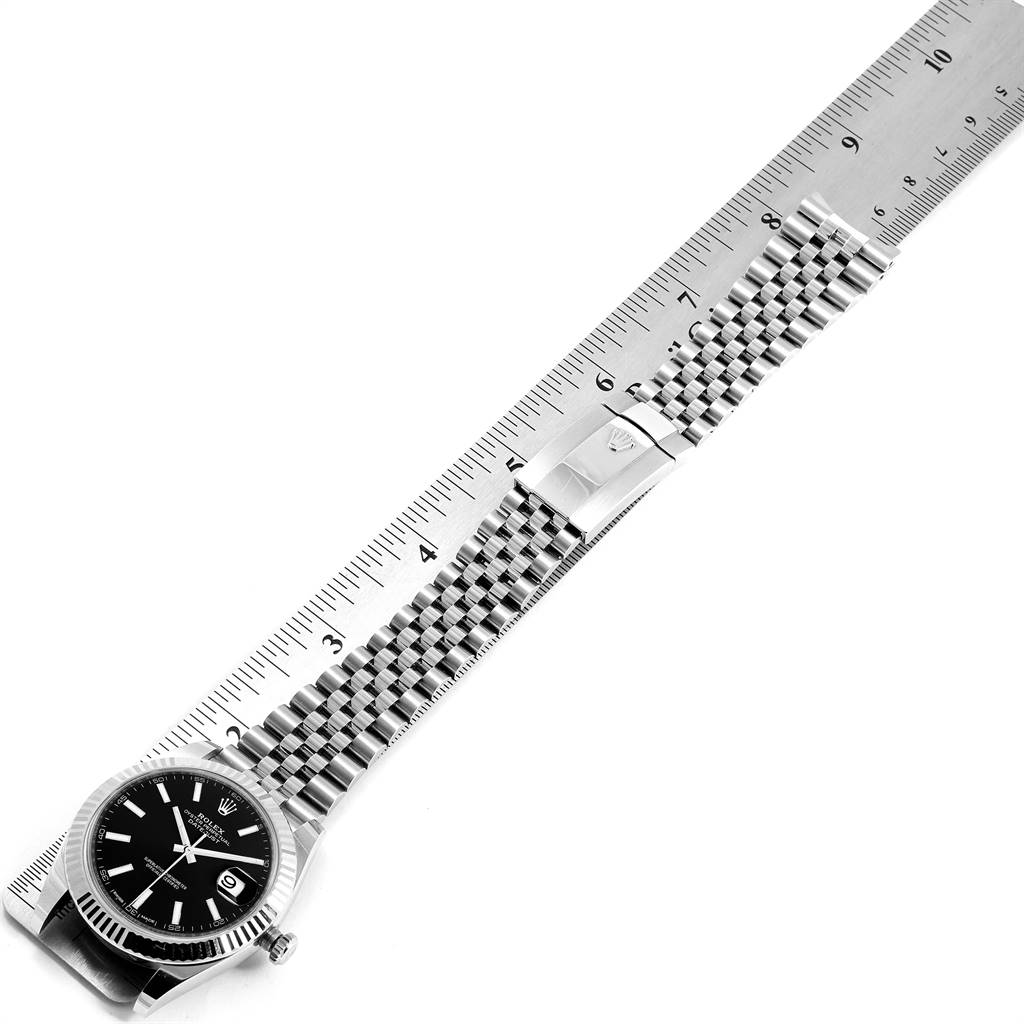 The image shows the full length of a Rolex Datejust 41 126334 Men's Stainless Steel Black Dial 126334 Men's Stainless Steel Black Dial watch laid next to a ruler, highlighting its bracelet and clasp.