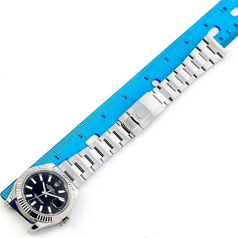 The image shows a top-down view of a Rolex Datejust 41 116334 Men's Stainless Steel Black Dial 116334 Men's Stainless Steel Black Dial watch alongside a blue ruler, displaying the watch face and metal bracelet.