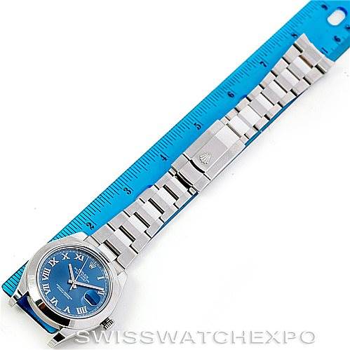 The image shows a Rolex Datejust 41 116300 Men's Stainless Steel Blue Dial 116300 Men's Stainless Steel Blue Dial model watch laid flat against a blue ruler, displaying the full bracelet and blue dial.