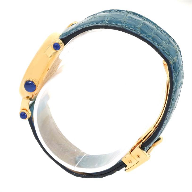 The image shows a side view of the Cartier Diabolo 1400 Women
s Yellow Gold Silver Dial 1400 Women
s Yellow Gold Silver Dial watch, highlighting its blue strap and gold case with blue accents.