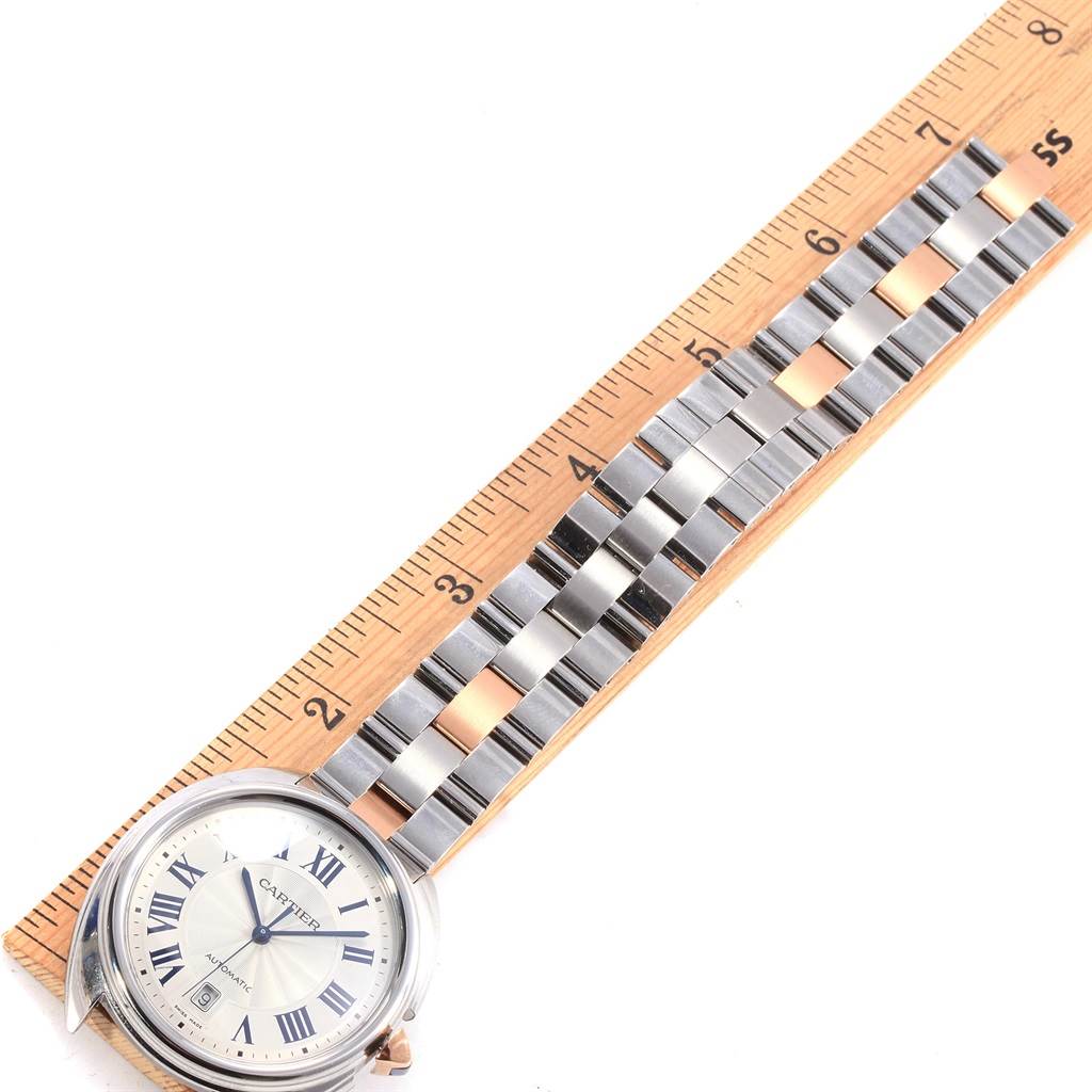 This image shows the Cartier Cle W2CL0002 Men's Steel and Gold (two tone) Silver Dial W2CL0002 Men's Steel and Gold (two tone) Silver Dial watch at an overhead angle, highlighting the watch face and metal bracelet alongside a ruler.