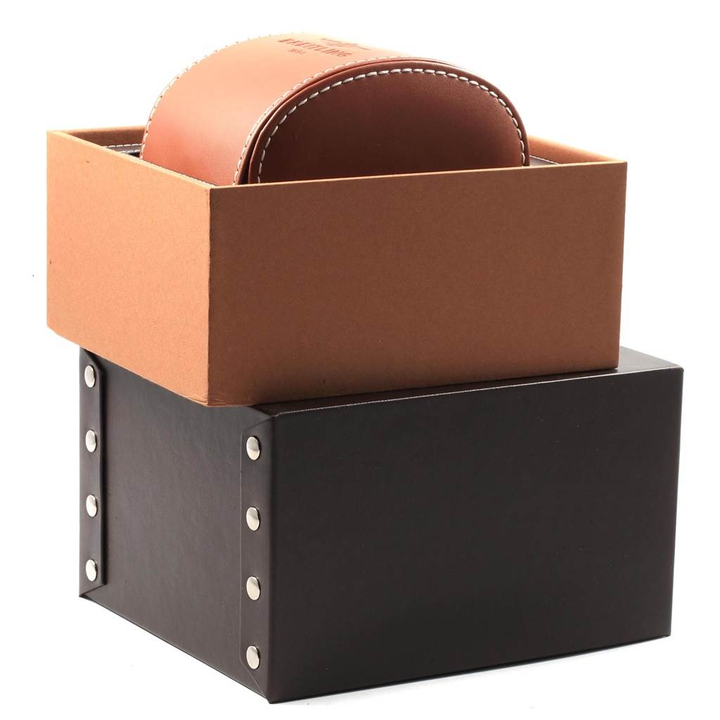 The image shows the packaging for a Breitling Transocean AB015212/BA99/154A Men's Stainless Steel Black Dial AB015212/BA99/154A Men's Stainless Steel Black Dial watch, featuring a brown leather case inside a brown box, all placed on top of a black base.