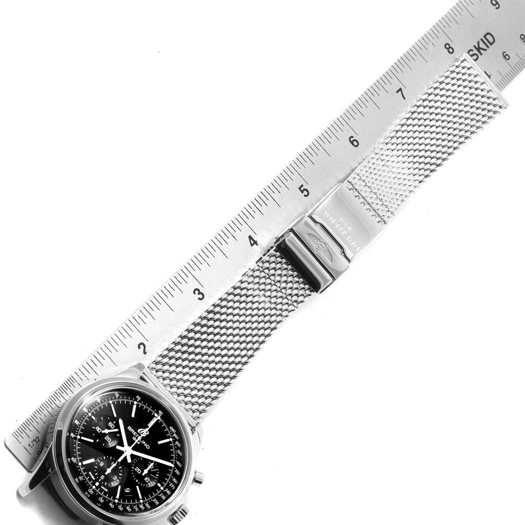 The Breitling Transocean AB015212/BA99/154A Men's Stainless Steel Black Dial AB015212/BA99/154A Men's Stainless Steel Black Dial watch is shown from an overhead angle, including the face, mesh bracelet, and clasp alongside a ruler.