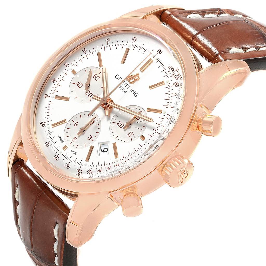 The image shows a side angle view of the Breitling Transocean RB0152 Men's Rose Gold Silver Dial RB0152 Men's Rose Gold Silver Dial watch, highlighting the face, chronograph dials, case, and brown leather strap.