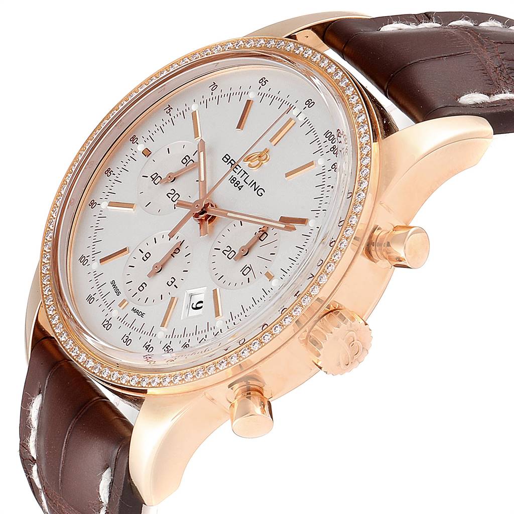 This image shows a side-angle view of the Breitling Transocean RB0152 Men's Rose Gold Silver Dial RB0152 Men's Rose Gold Silver Dial watch, highlighting its crown, chronograph pushers, and leather strap.