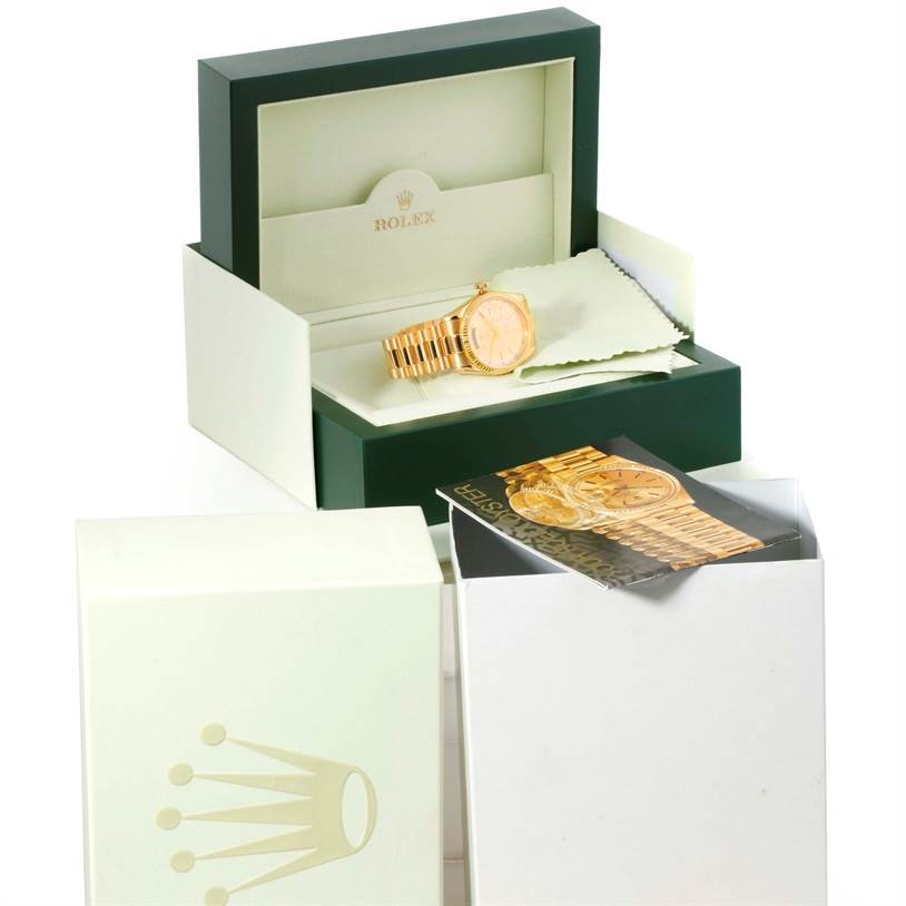 The image shows a Rolex President 118238 Men's Yellow Gold Silver Dial 118238 Men's Yellow Gold Silver Dial model watch in its open box with an information booklet and a cleaning cloth.