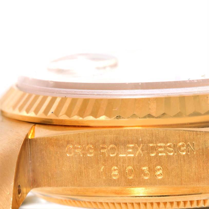 The image shows a side angle of the Rolex President 18038 Men
s Yellow Gold Silver Dial 18038 Men
s Yellow Gold Silver Dial model watch, featuring its bezel and engraved case with the model number 18038.