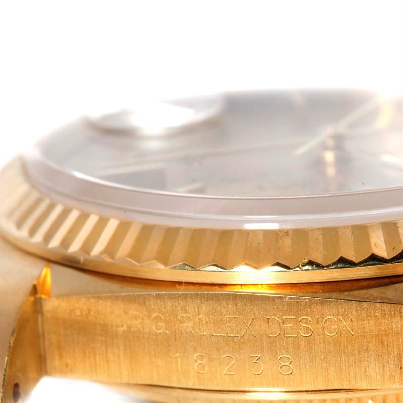 This close-up image of the Rolex President 18238 Men
s Yellow Gold Champagne Dial 18238 Men
s Yellow Gold Champagne Dial model shows the side of the case with the reference number and part of the fluted bezel.
