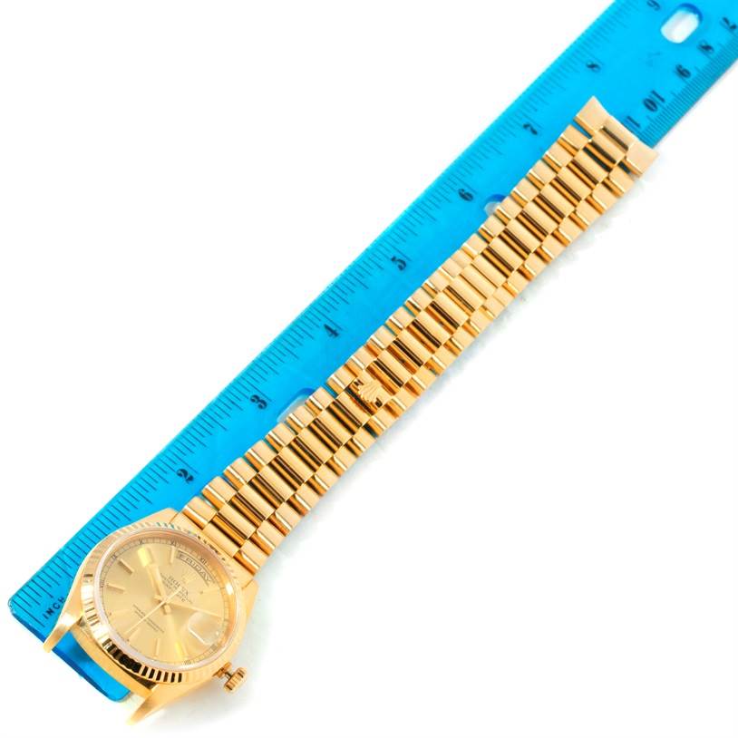 The image shows a Rolex President 18238 Men
s Yellow Gold Champagne Dial 18238 Men
s Yellow Gold Champagne Dial model watch lying flat with a ruler measuring the length of its gold bracelet.