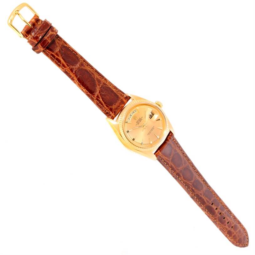 The Rolex President 1803 Men
s Yellow Gold Champagne Dial 1803 Men
s Yellow Gold Champagne Dial watch is shown at a top-down angle, displaying the gold dial, case, crown, and brown leather strap.