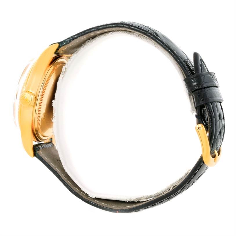 This side view of the Rolex President 1803 Men
s Yellow Gold White Dial 1803 Men
s Yellow Gold White Dial model watch shows the golden case, crown, and black leather strap with a golden buckle.