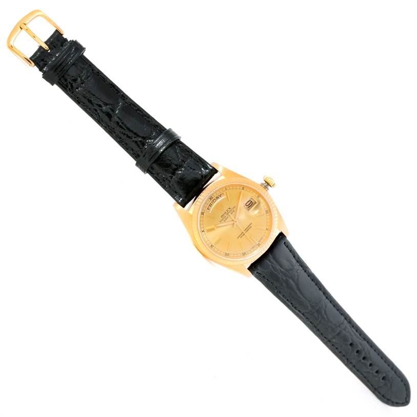 The Rolex President 18038 Men
s Yellow Gold Champagne Dial 18038 Men
s Yellow Gold Champagne Dial model watch is shown from a top-down angle, highlighting its gold case, dial, crown, and black leather strap.