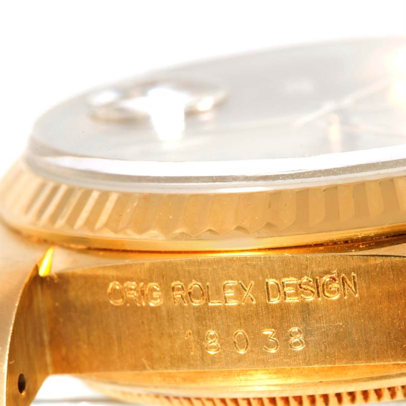 The image shows a close-up side view of the case of a Rolex President 18038 Men
s Yellow Gold Champagne Dial 18038 Men
s Yellow Gold Champagne Dial model, highlighting its engraved design number and part of the bezel.