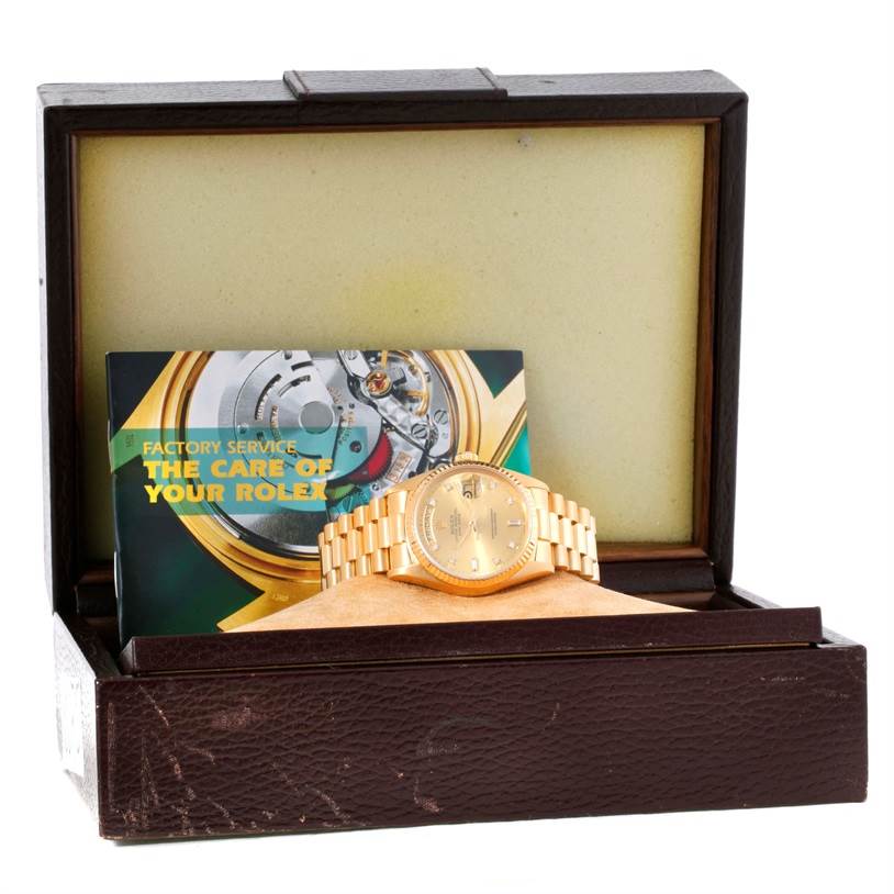 The image shows a Rolex President 18038 Men
s Yellow Gold Champagne Dial 18038 Men
s Yellow Gold Champagne Dial model watch in its box along with a factory service booklet.