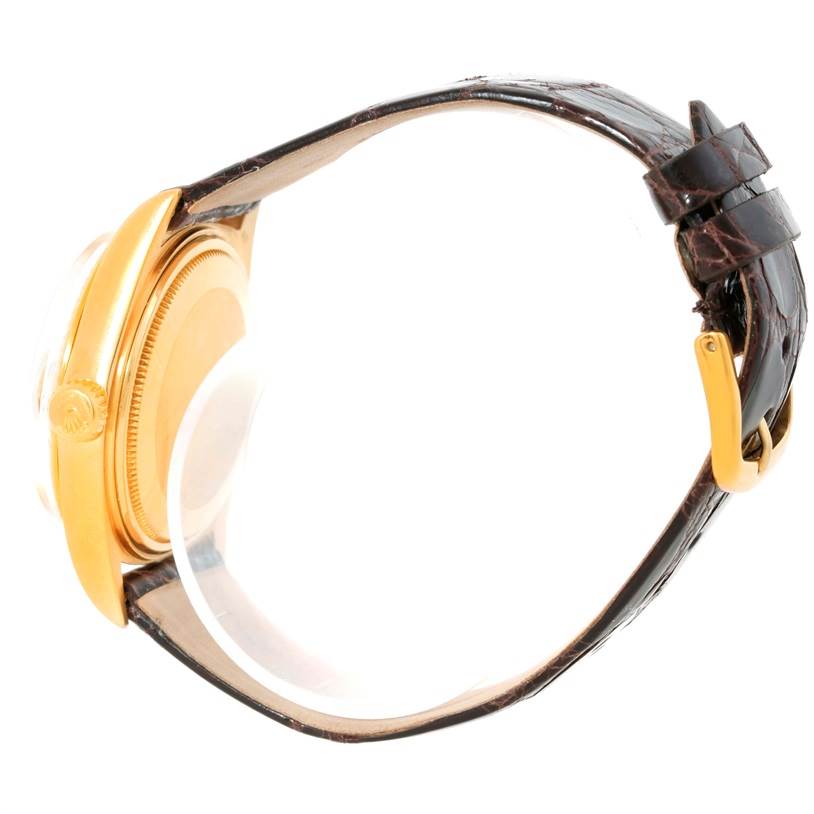 This image shows a side view of a Rolex President 1803 Men
s Yellow Gold Champagne Dial 1803 Men
s Yellow Gold Champagne Dial model watch, highlighting the gold case, crown, and leather strap with a buckle.