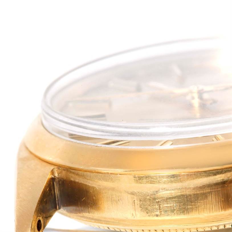The image shows a close-up side view of a Rolex President 1500 Men
s Yellow Gold Champagne Dial 1500 Men
s Yellow Gold Champagne Dial model watch, highlighting part of the case and crystal.
