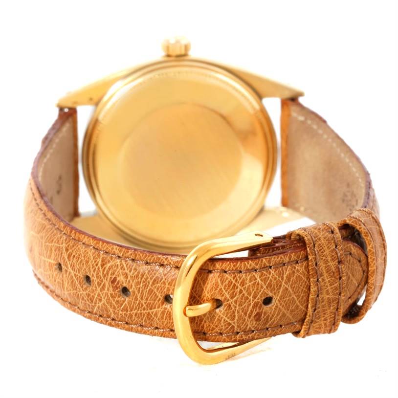 The image shows the back and side of a Rolex President 1500 Men
s Yellow Gold Champagne Dial 1500 Men
s Yellow Gold Champagne Dial model with its leather strap and gold buckle.