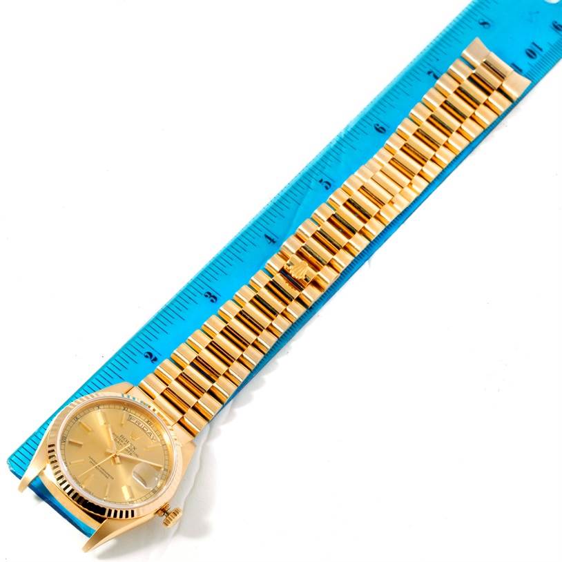 The image shows a top-down view of a Rolex President 18238 Men
s Yellow Gold Champagne Dial 18238 Men
s Yellow Gold Champagne Dial watch, displaying the watch face, case, and full bracelet placed on a blue ruler.