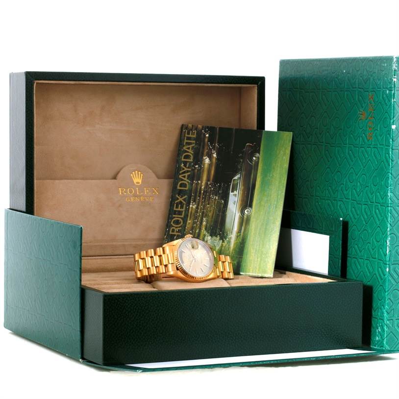 The image shows a Rolex President 18238 Men
s Yellow Gold Champagne Dial 18238 Men
s Yellow Gold Champagne Dial model watch inside its green box with a Day-Date booklet next to it.
