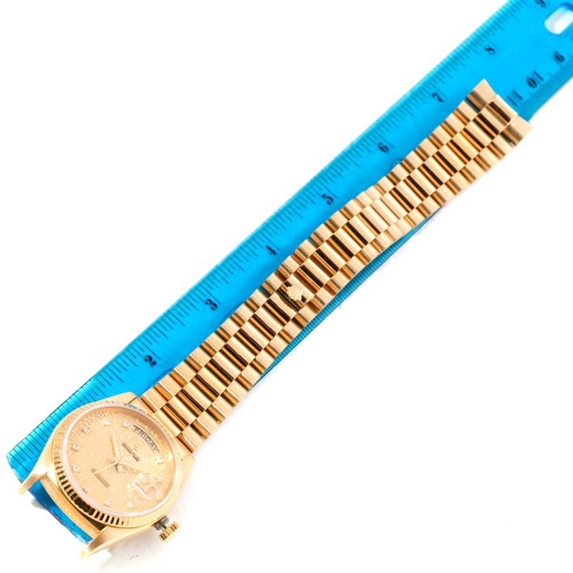 The image shows a top-down view of the Rolex President 18038 Men
s Yellow Gold Champagne Dial 18038 Men
s Yellow Gold Champagne Dial model watch and its bracelet, measured against a blue ruler.