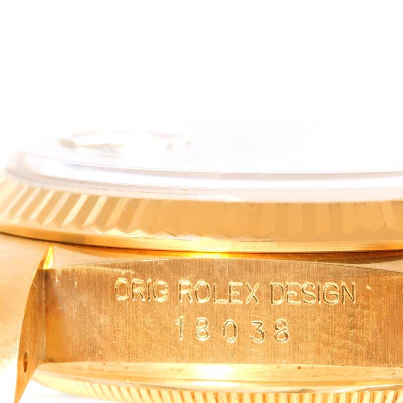 The image shows a close-up of the side and bezel of a Rolex President 18038 Men
s Yellow Gold Champagne Dial 18038 Men
s Yellow Gold Champagne Dial model with the "Orig Rolex Design" and model number 18038 engraved.