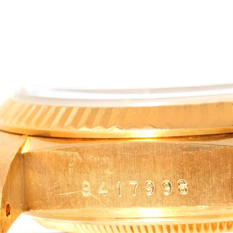 This close-up image shows the side view of a Rolex President 18038 Men
s Yellow Gold Champagne Dial 18038 Men
s Yellow Gold Champagne Dial model
s gold case with its serial number engraved.