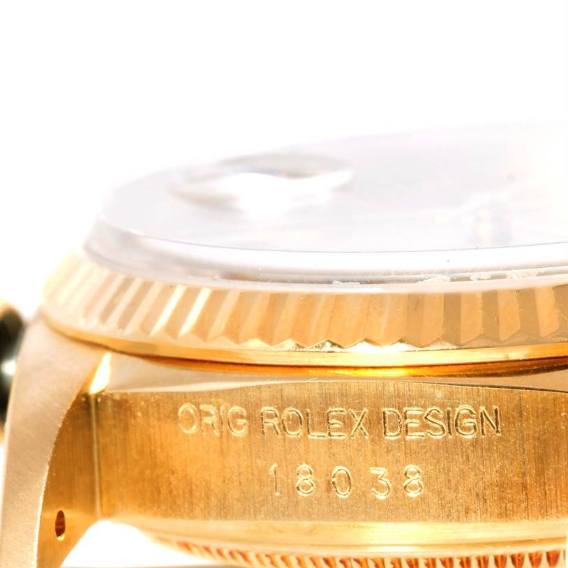 This close-up image shows the side profile of the bezel and case of a Rolex President 18038 Men
s Yellow Gold Champagne Dial 18038 Men
s Yellow Gold Champagne Dial model with visible engravings.