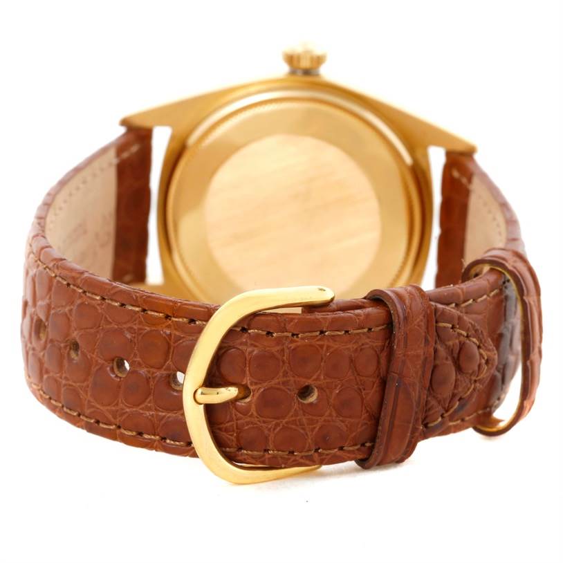 The image shows the back view of a Rolex President 1803 Men
s Yellow Gold Champagne Dial 1803 Men
s Yellow Gold Champagne Dial model watch with a brown leather strap and gold buckle.