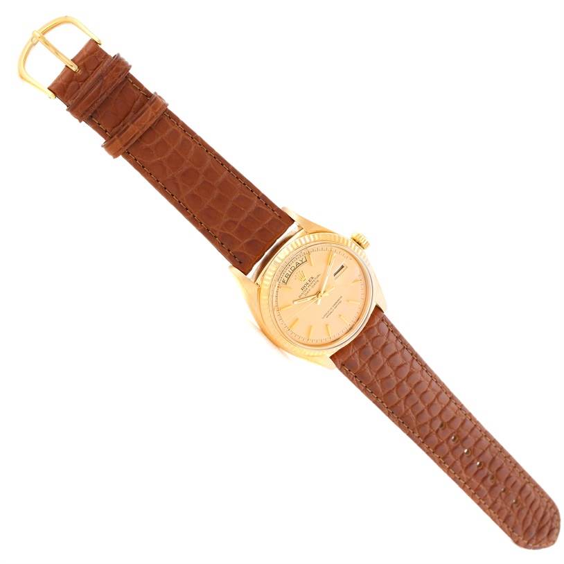 The Rolex President 1803 Men
s Yellow Gold Champagne Dial 1803 Men
s Yellow Gold Champagne Dial model watch is shown from a top-down angle, showcasing its face, crown, and brown leather strap.