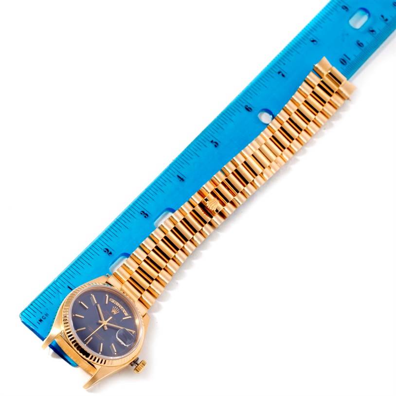 The image shows a Rolex President 18038 Men's Yellow Gold Blue Dial 18038 Men's Yellow Gold Blue Dial watch laid flat against a blue ruler, displaying the face and full length of the band.