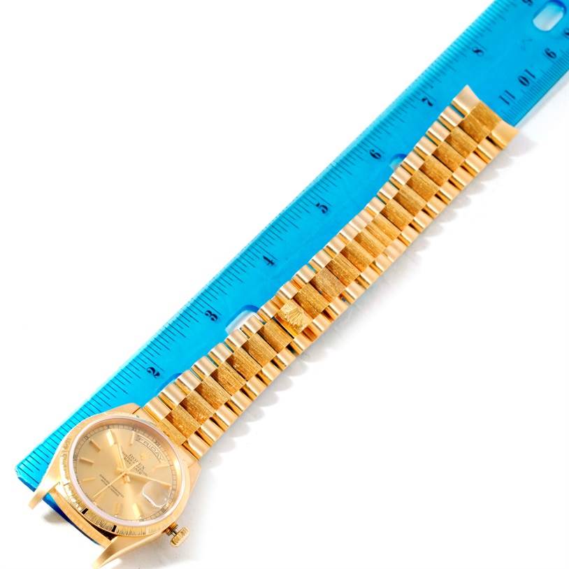 The image shows a side view of a Rolex President 18248 Men
s Yellow Gold Champagne Dial 18248 Men
s Yellow Gold Champagne Dial model watch, highlighting its gold band and face next to a blue ruler for scale.