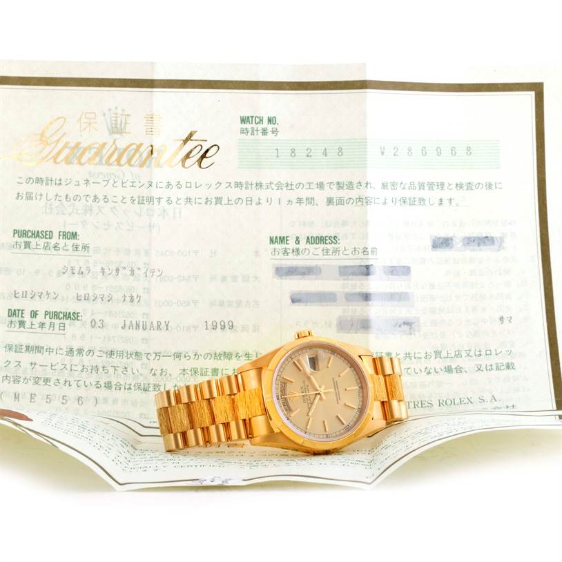 The image shows a Rolex President 18248 Men
s Yellow Gold Champagne Dial 18248 Men
s Yellow Gold Champagne Dial model watch placed on top of its guarantee document, displayed at a slight angle.
