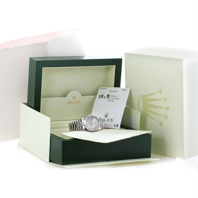 The Rolex President 118209 Men's White Gold Silver Dial 118209 Men's White Gold Silver Dial model watch is shown in its open box, accompanied by warranty cards and a cloth.