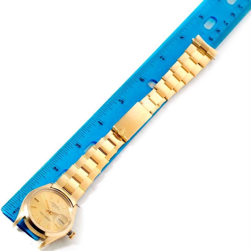 The image shows a Rolex President 1500 Men
s Yellow Gold Champagne Dial 1500 Men
s Yellow Gold Champagne Dial model watch laid flat next to a blue ruler, displaying the complete band and face.