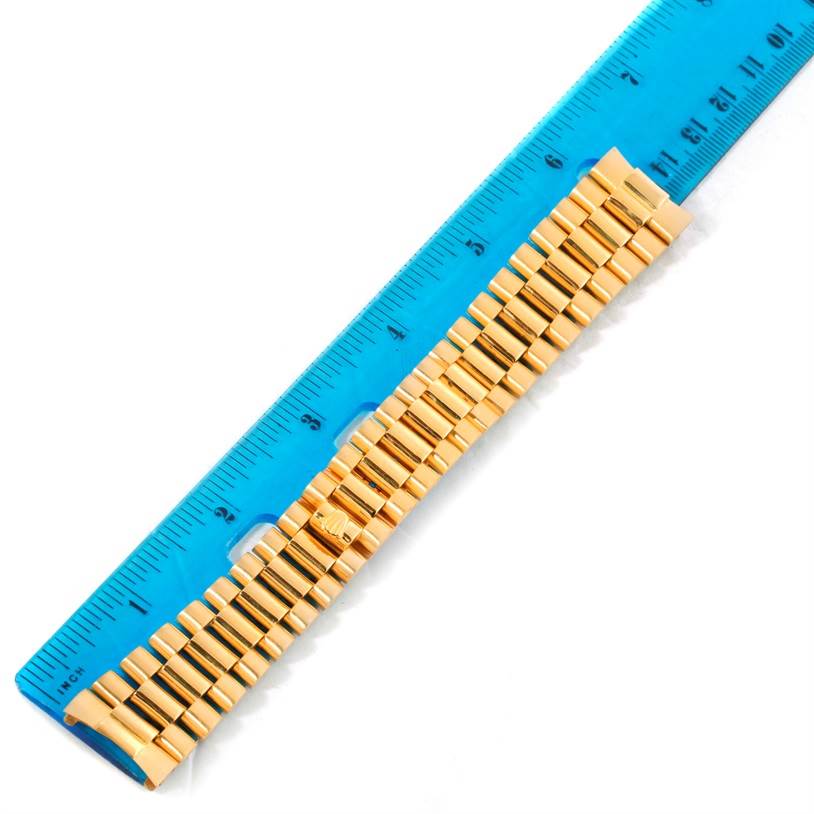This image shows a gold bracelet of a Rolex President 1803 Men's  1803 Men's  model watch with a blue ruler for scale.