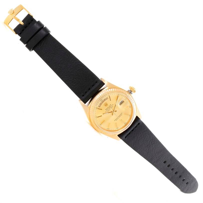 The image shows a Rolex President 1803 Men
s Yellow Gold Champagne Dial 1803 Men
s Yellow Gold Champagne Dial model watch, angled from above, featuring a gold dial and black leather strap.