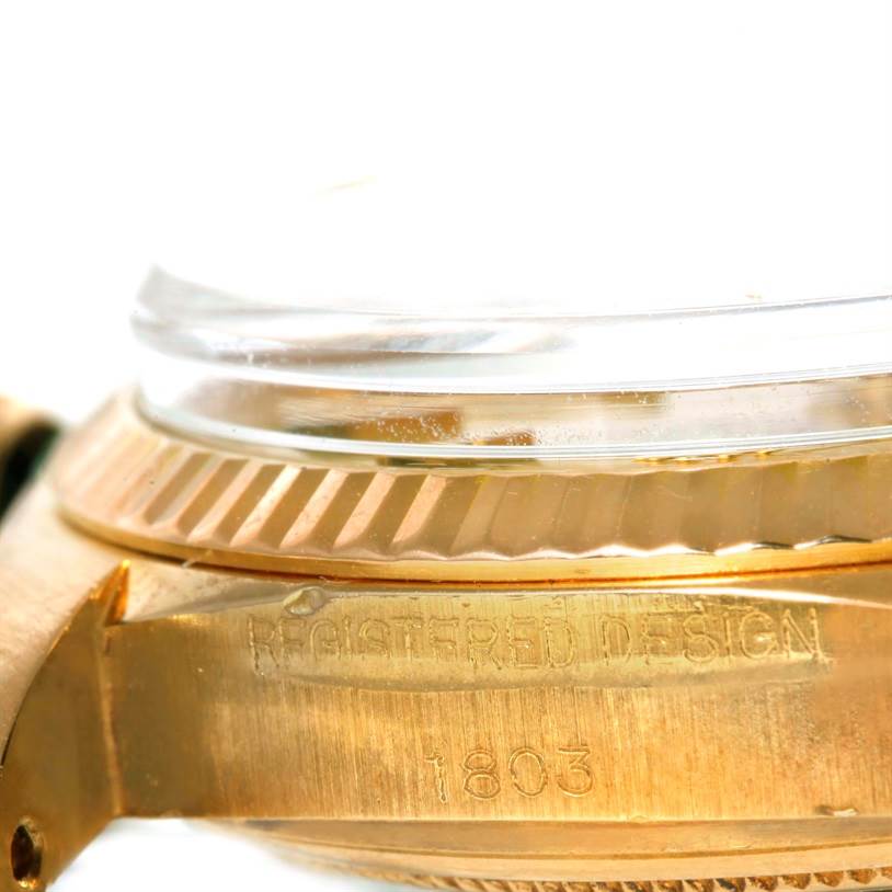 The image shows a close-up side view of the case and bezel of a Rolex President 1803 Men
s Yellow Gold Champagne Dial 1803 Men
s Yellow Gold Champagne Dial model watch, highlighting the text "REGISTERED DESIGN 1803."