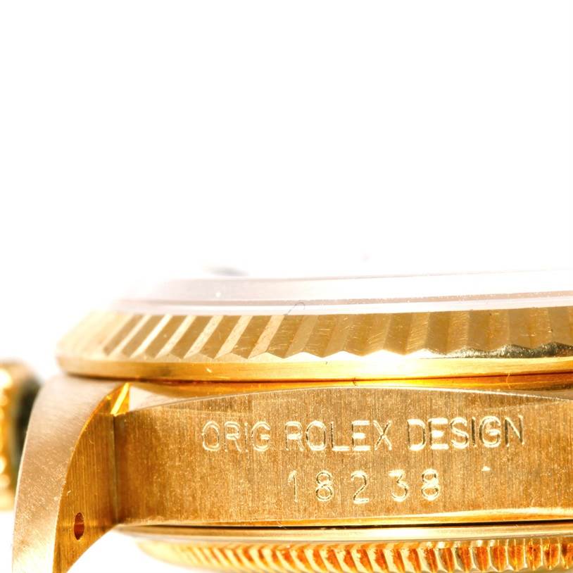 This close-up image shows the side of a Rolex President 18238 Men's Yellow Gold Beige Dial 18238 Men's Yellow Gold Beige Dial model, highlighting the bezel and engraved case detailing.
