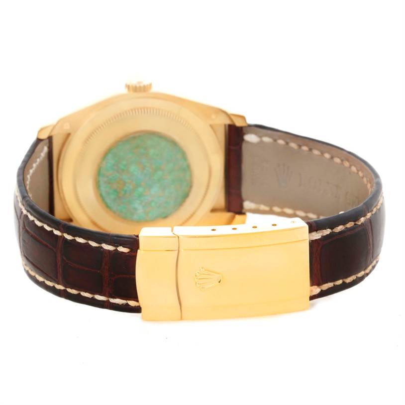 The image shows the back and clasp of a Rolex President 116138 Men's Yellow Gold White Dial 116138 Men's Yellow Gold White Dial model watch with a gold case and a leather strap.