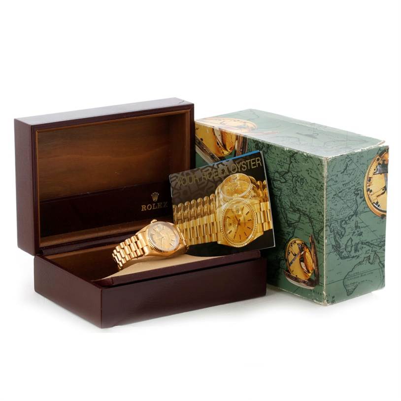 The Rolex President 18238 Men
s Yellow Gold Champagne Dial 18238 Men
s Yellow Gold Champagne Dial model watch and its accessories are shown at an angle, placed in an open display box with the outer box beside it.