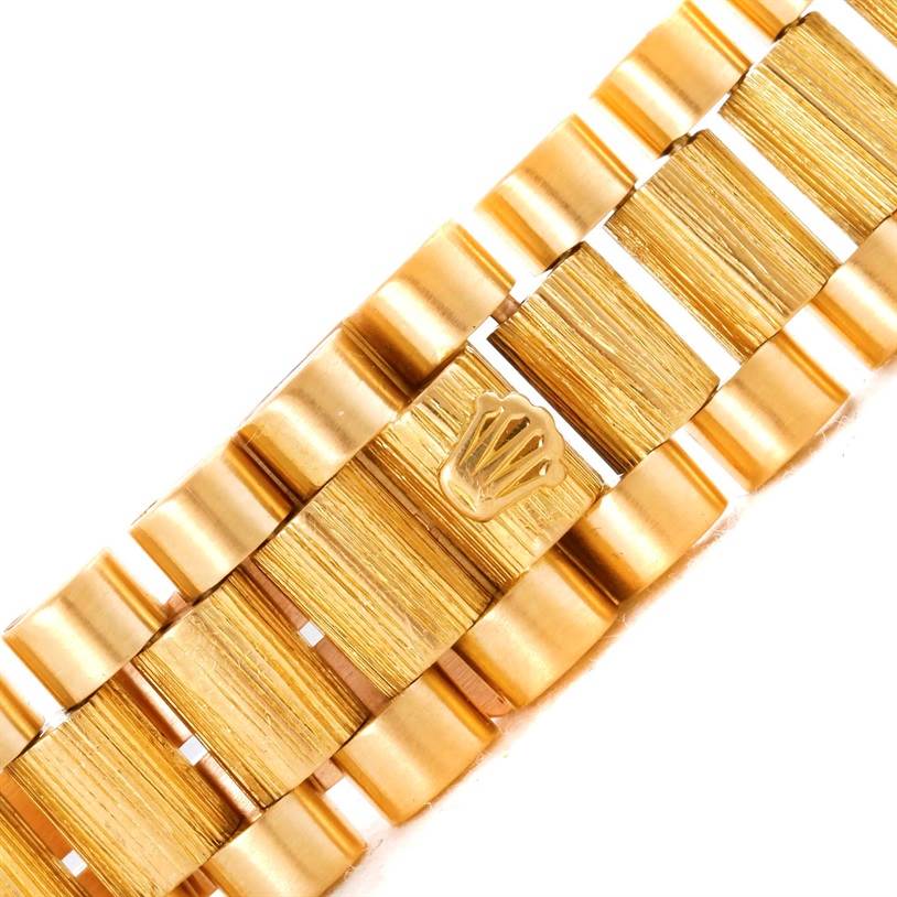 This close-up image shows the gold bracelet with the Rolex logo of a President model by Rolex.